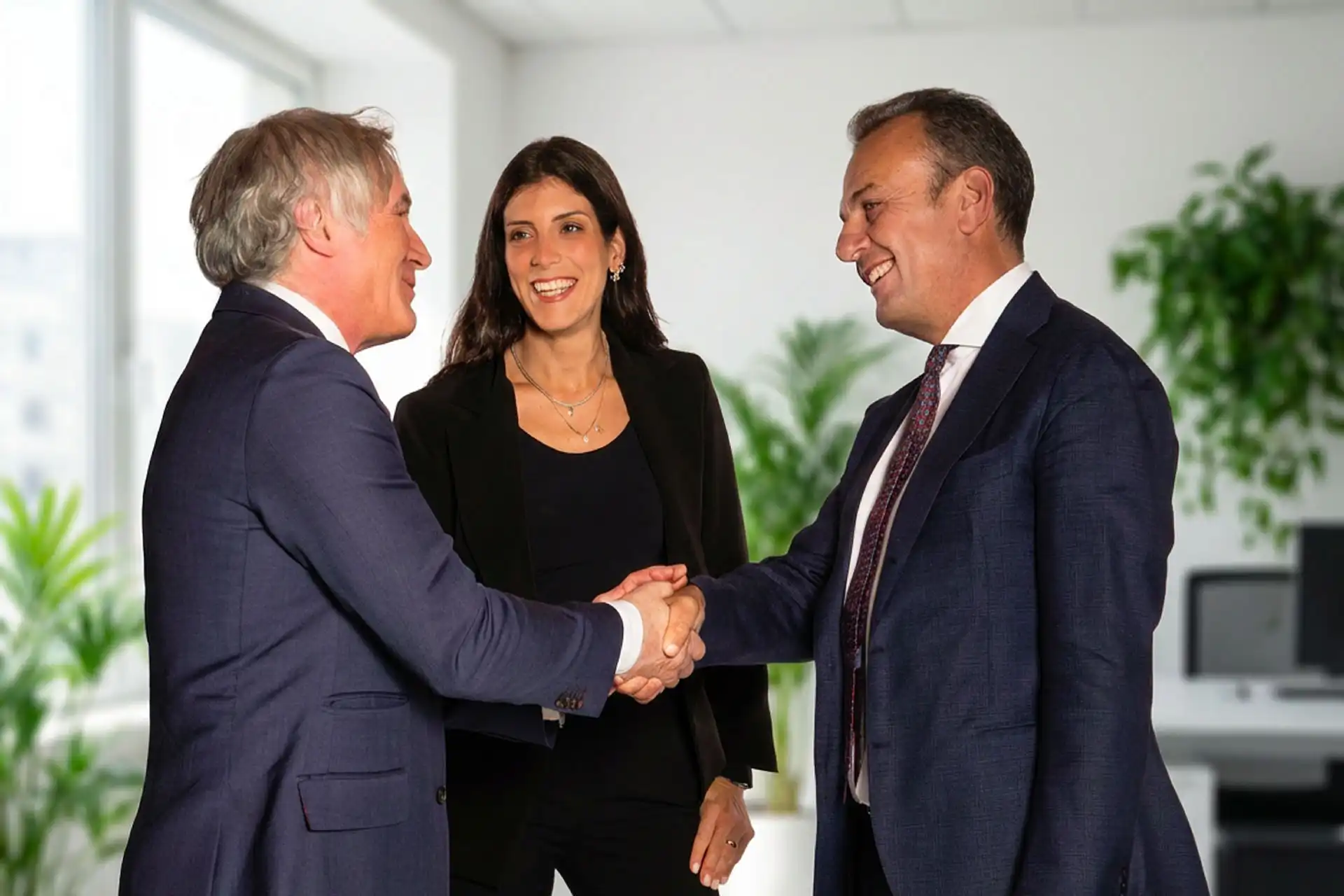 Fotografia di Edoardo Ginevra e Michele Pirotta che si straingono la mano. In mezzo a loro Claudia Barzaghi